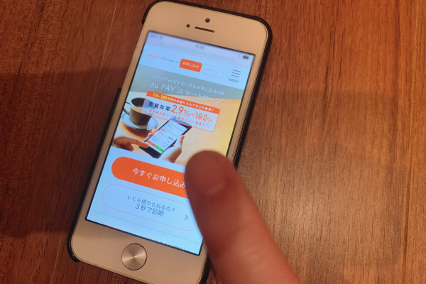 スマホに公式サイトの画面を出している画像